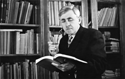 Naum Akhiezer reading a book in his study